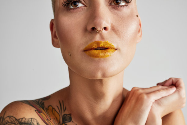 一个美丽的年轻女子在一个灰色的背景下摆姿势的工作室拍摄图片下载