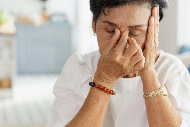 一位年长的亚洲妇女用手抓住头部。上了年纪的妇女会因为压力而头晕头痛。她有先天性疾病。退休的健康概念图片下载