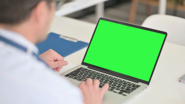 中年男性医生使用带彩色屏幕的笔记本电脑图片下载