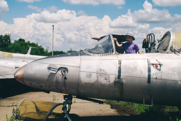 一架军用战斗机飞行员座舱的特写镜头。玻璃上有一条裂缝，由于年代久远已经发黄了。退役的军事装备。飞机飞行员的座位图片下载