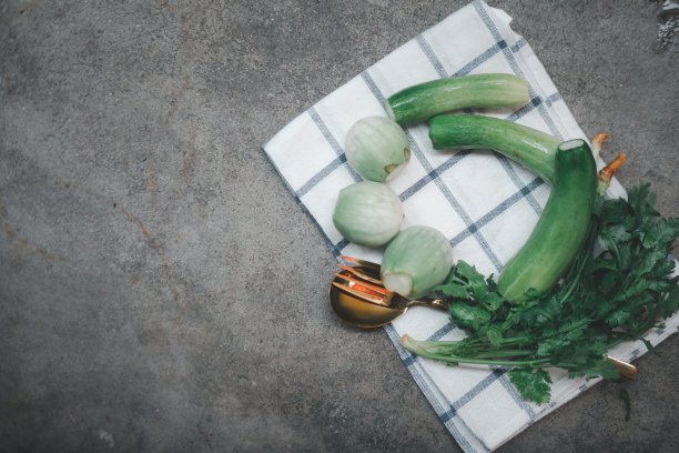 把黄瓜、茄子和香菜按餐具分门别类摆放在桌子上。准备好的蔬菜配菜上桌图片下载