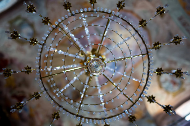 教堂里美丽的水晶吊灯。后面是一个模糊的、装饰华丽的拱顶。图片下载