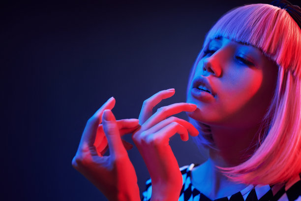 在工作室的年轻女孩的肖像与红色和蓝色霓虹灯金发图片下载