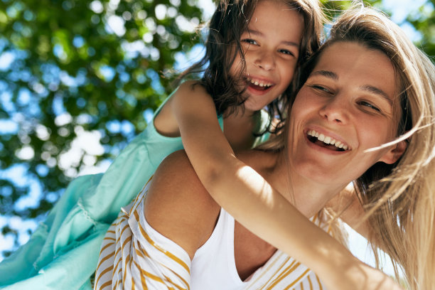 一个快乐的母亲和她快乐的女儿在公园野餐的肖像。在一个阳光明媚的日子里，快乐的女人和小女孩微笑着共度时光。母亲节概念。图片下载