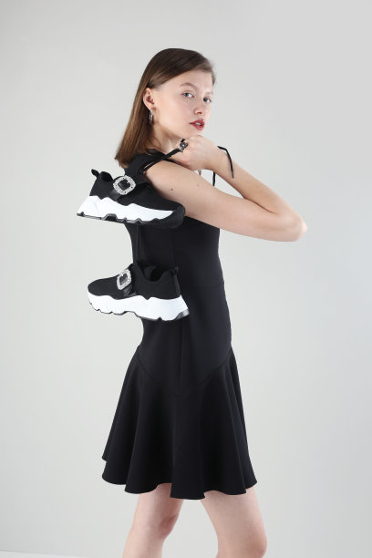 年轻美丽的女人在白色的背景下穿着休闲服装和运动鞋。图片下载