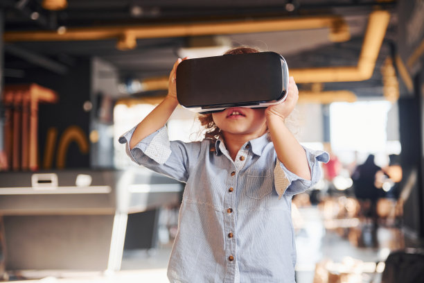 戴着虚拟现实眼镜和穿着休闲衣服的孩子在游戏室里玩得很开心图片下载