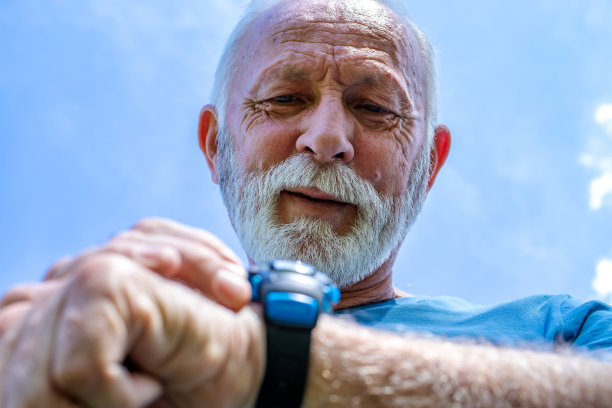 在户外训练后检查时间或身体状况的高级人员。图片下载