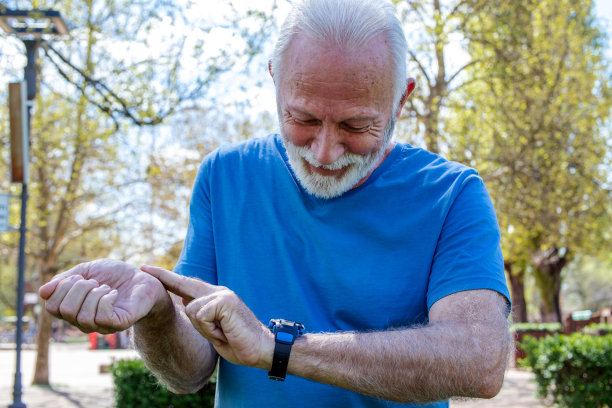 在户外训练后检查时间或身体状况的高级人员。图片下载