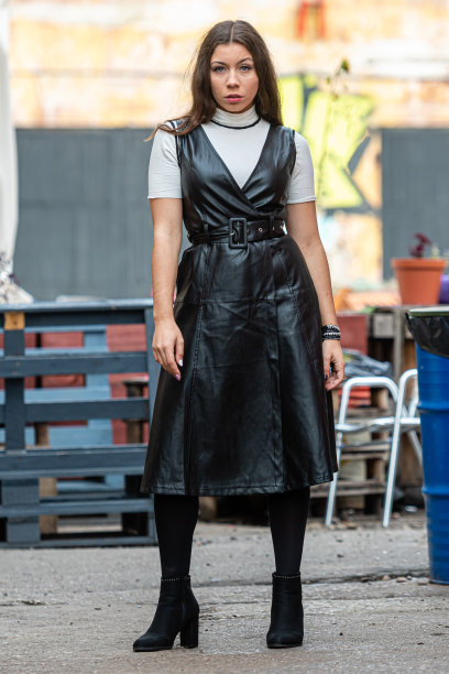 令人惊叹的年轻女子在一个模糊的户外咖啡馆背景黑色皮衣图片下载