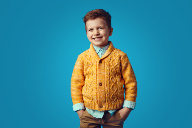 在蓝色背景下，一个孩子在口袋里牵着手微笑着图片下载