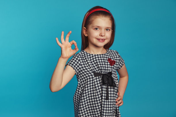 小女孩一只手放在腰上，做着不错的手势，喜欢完美的主意图片下载