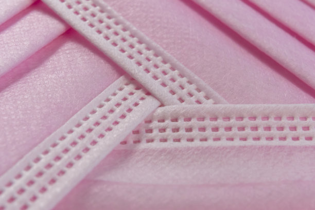 粉色医用一次性口罩以回收符号的形式堆叠在一起图片下载