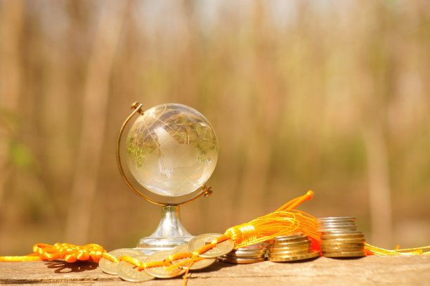 一个小玻璃球和一堆中国硬币的特写。图片下载