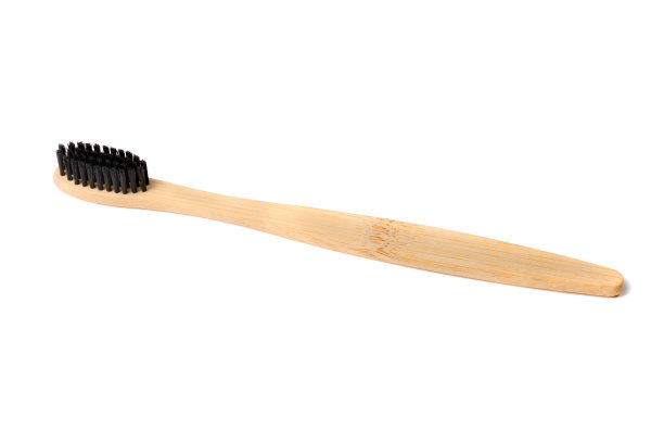 用天然木材制成的黑色刷毛牙刷，背景为白色图片下载