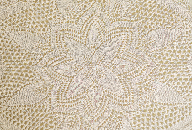 温暖的白色或米色编织花边桌布。钩编花边台布，手工花边纹理。抽象图案为背景。前视图。图片下载