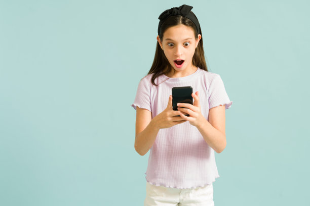 可爱的女孩在手机上看一些激动人心的东西图片下载