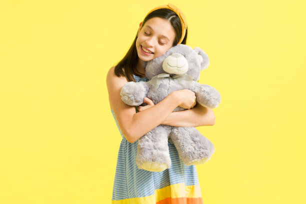 小女孩抱着泰迪熊玩得很开心图片下载