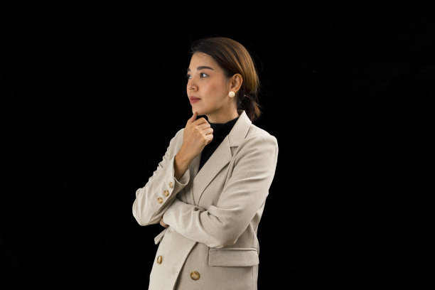 聪明的亚洲女商人，黑色背景下的棕色西装。图片下载