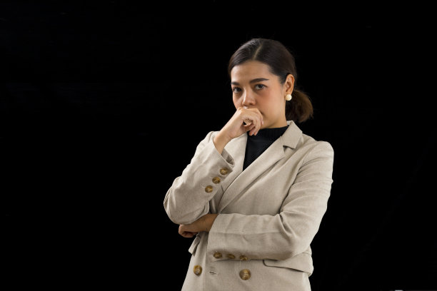 聪明的亚洲女商人，黑色背景下的棕色西装。图片下载