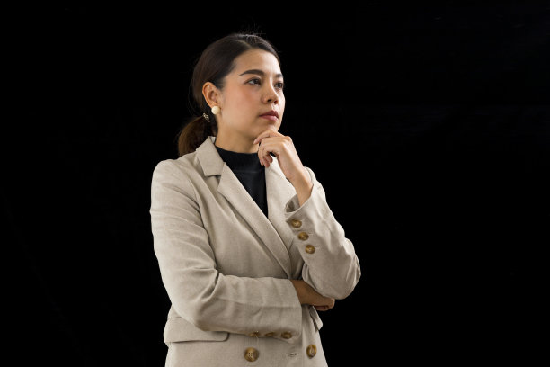 聪明的亚洲女商人，黑色背景下的棕色西装。图片下载