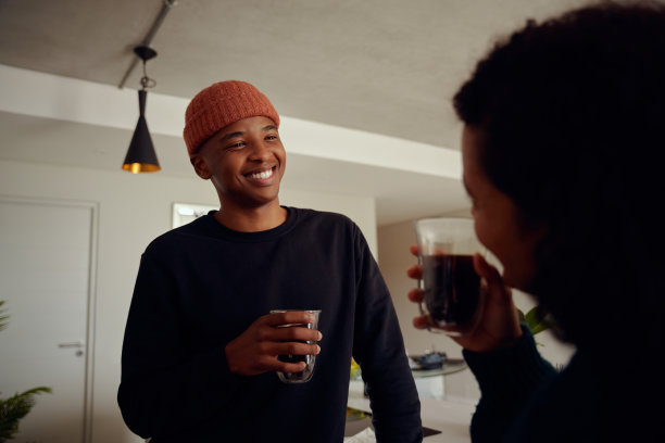 混血夫妇一起喝咖啡。年轻，快乐的非裔美国男人对着他的女性伴侣微笑。高质量的照片图片下载