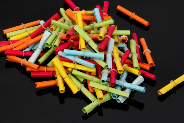 一堆彩色的彩票在黑色的地面上图片下载