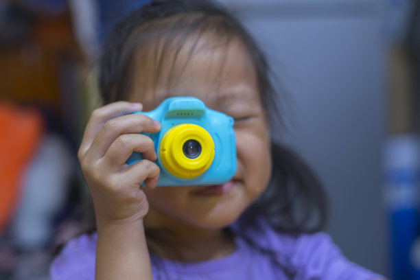 给别人拍照。小女孩用玩具相机拍照，摄影课程。拿着相机图片下载