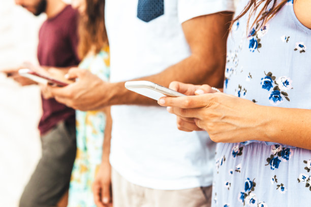一群在户外使用智能手机的朋友——年轻人花时间与互联网技术和社交网络成瘾的手机概念在一起。图片下载