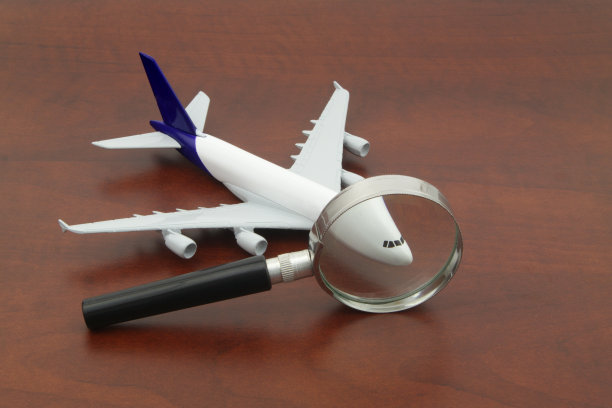 检查机票的价格。放大镜下的飞机模型。图片下载