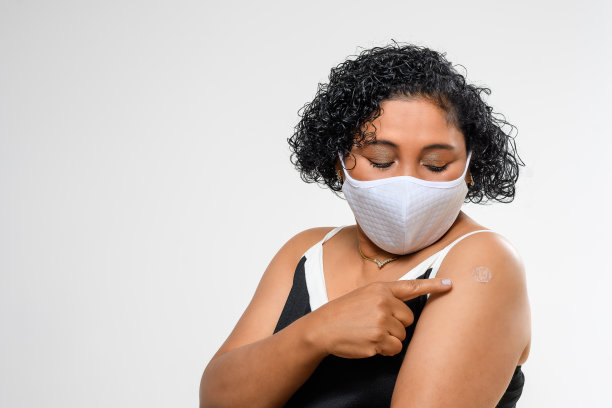 一名妇女在手臂上展示疫苗贴片。新型冠状病毒肺炎图片下载