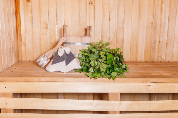 传统的俄罗斯澡堂水疗概念。室内细节芬兰桑拿蒸汽房与传统桑拿配件盆桦木扫帚勺毛毡。放松乡村乡村浴概念图片下载