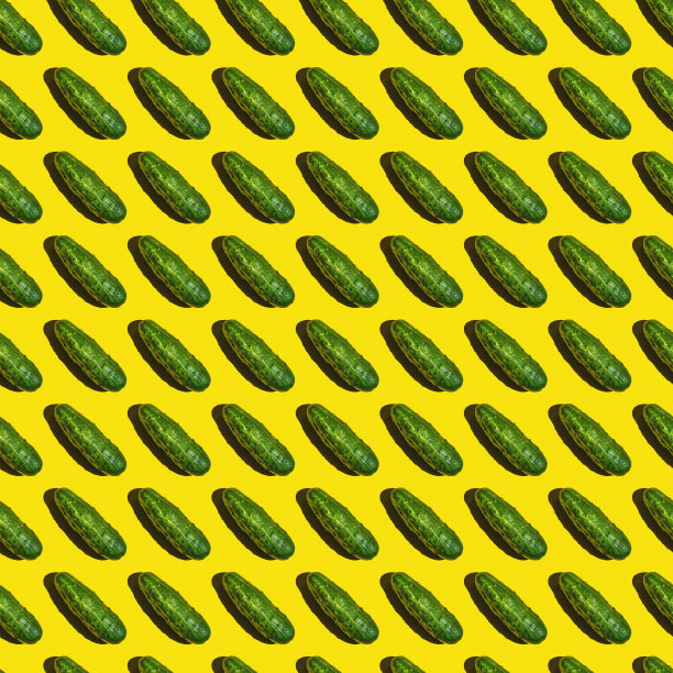 质地无缝的背景图案是鲜绿黄瓜上的黄色背景。图片下载