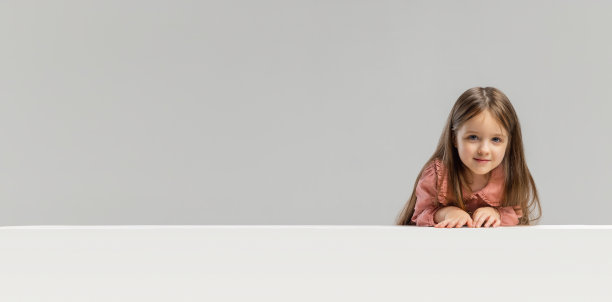 肖像的小高加索可爱的女孩摆出孤立的灰色工作室背景。图片下载