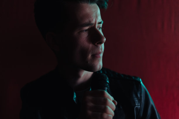 穿着皮夹克的男子在俱乐部黑暗的舞台上表演图片下载