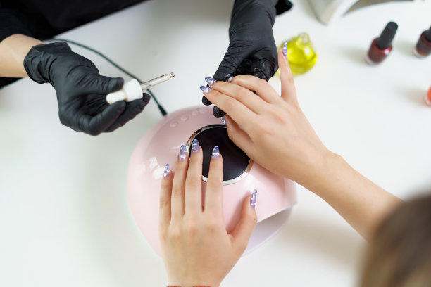 在美容院接待客户的美甲师。修指甲，在指甲上画画图片下载