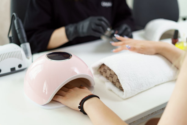 在美容院接待客户的美甲师。修指甲，在指甲上画画图片下载