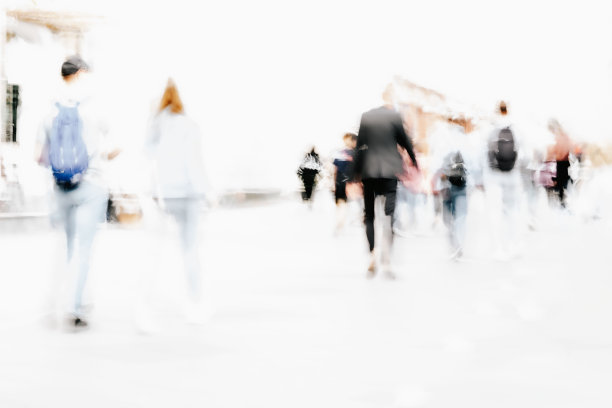 抽象的散焦运动模糊了行走在城市街道上的人。城市现代化的背景。图片下载