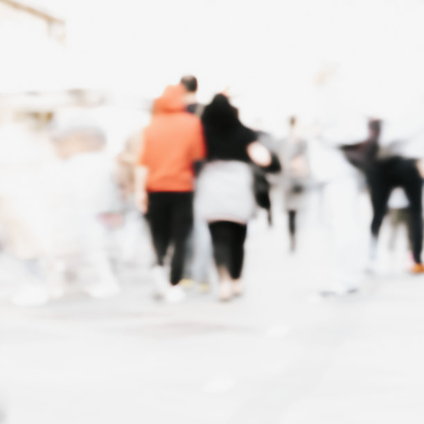 抽象的散焦运动模糊了行走在城市街道上的人。城市现代化的背景图片下载