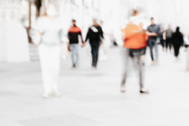抽象的散焦运动模糊了行走在城市街道上的人。城市现代化的背景图片下载