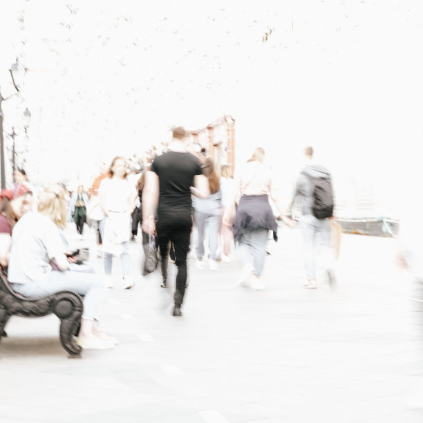 抽象的散焦运动模糊了行走在城市街道上的人。城市现代化的背景图片下载