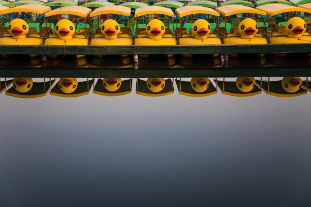 中国北京北海公园的黄色鸭子船。北海公园的白塔图片下载