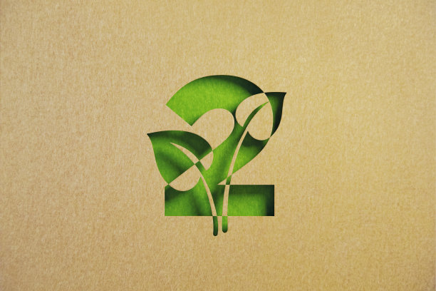 可持续发展的概念-剪出树叶形状的再生纸与数字2相交在绿色的背景图片下载