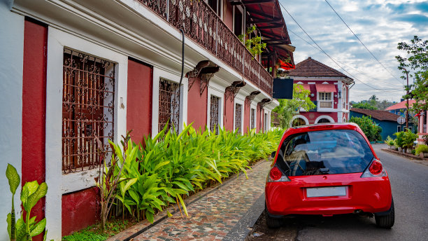 一辆红色的车停在街上的大楼附近图片下载