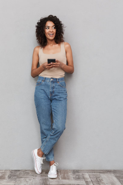 一个微笑的年轻非洲妇女的全长肖像图片下载