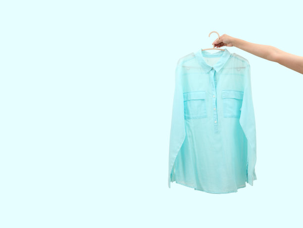 女士手拿淡色棉衬衫孤立在淡色背景和自由空间的文本图片下载