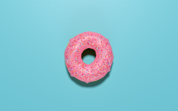 一个带粉色糖霜和糖屑的油炸圈饼。图片下载