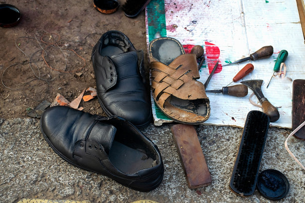 本地印度鞋店或鞋店的库存照片。修鞋工具有皮革、螺纹、刀具、刷子、支架等多种。照片拍摄于印度马哈拉施特拉邦科尔哈布尔。图片下载