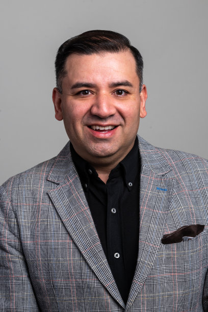 微笑的成熟男子看着灰色背景的相机图片下载