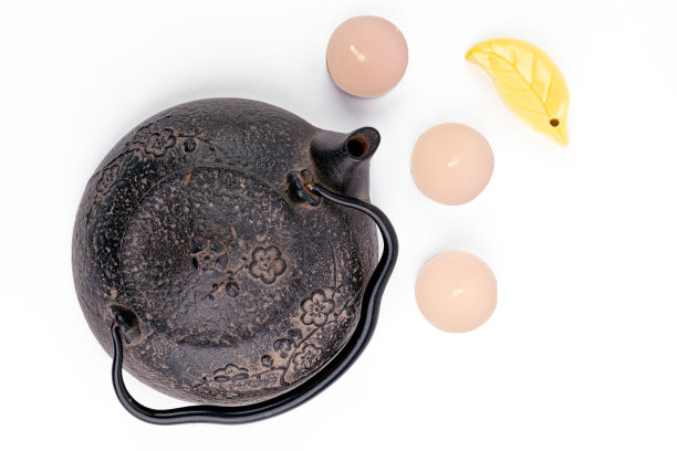 年份，黑色金属日本茶壶孤立在白色背景和茶蜡烛。极简茶道概念。图片下载