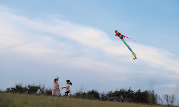 亚洲女孩在草地上玩和放风筝。图片下载